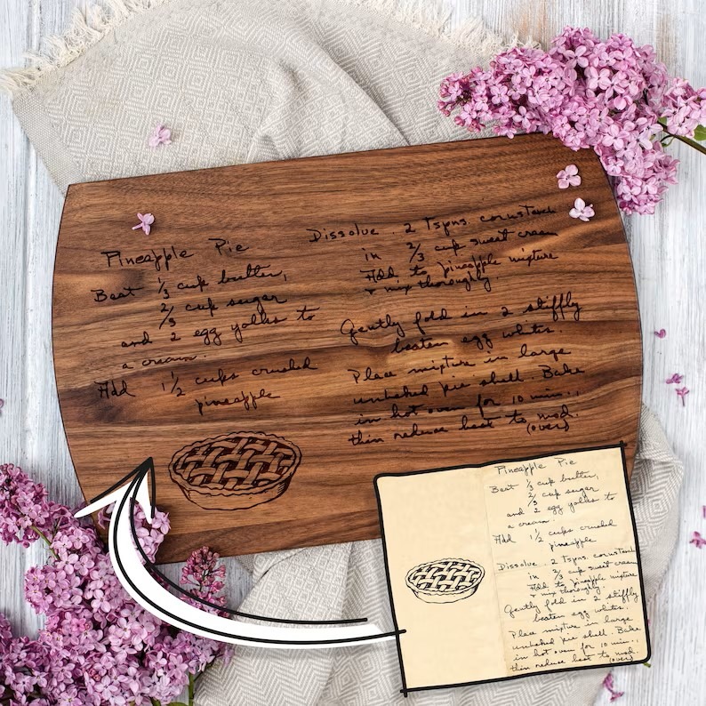 A personalized wood recipe cutting board with a handwritten note on it.