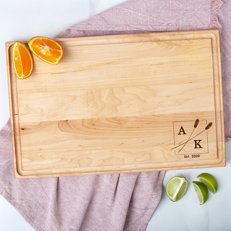 An engraved maple cutting board with orange slices on it.