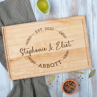 Personalized chopping board with engraved names on top of a table.