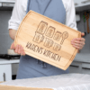 A woman is holding up a Custom Wooden Chopping Board that says Karen's kitchen.