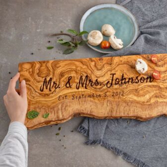 personalized olive wood live edge charcuterie board with the words Mr. & Mrs. and date underneath.