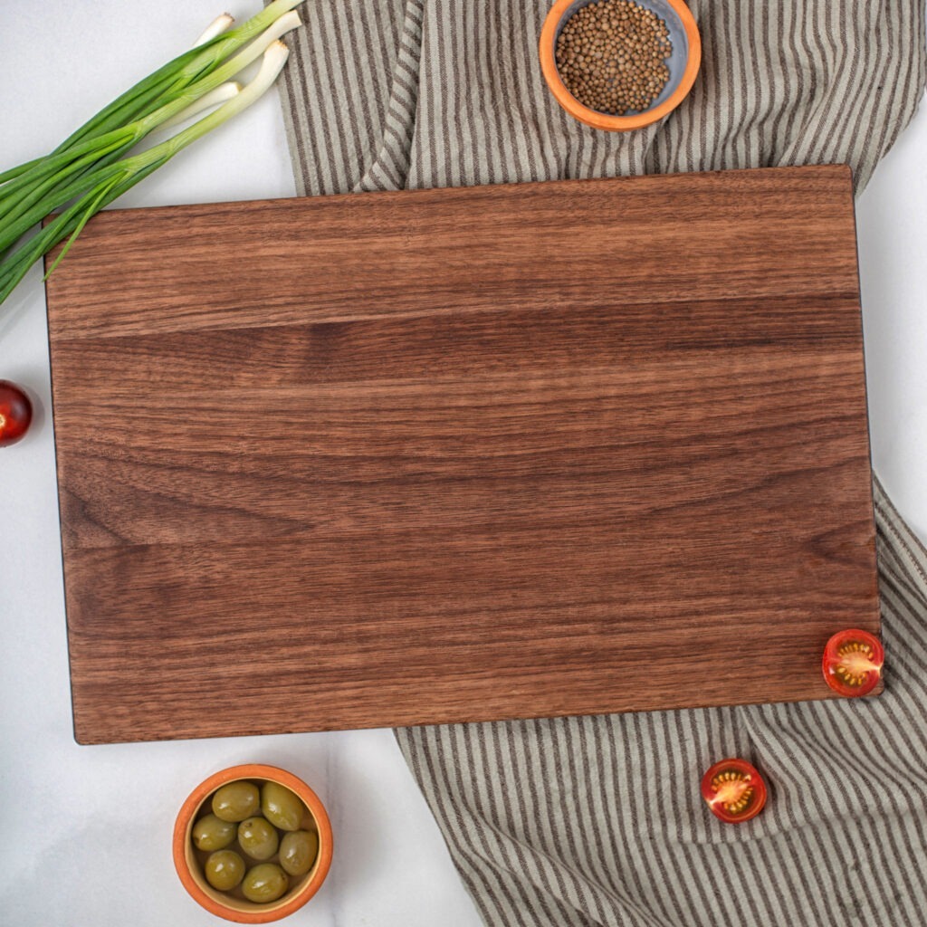 A wooden cutting board with olives and onions on it.