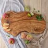 olive wood charcuterie board with apples and limes on it.