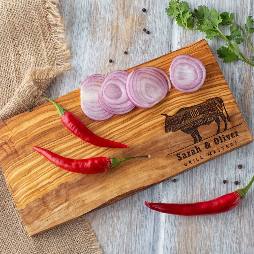 A Personalized Wooden Cutting Board with an image of a cow and peppers.