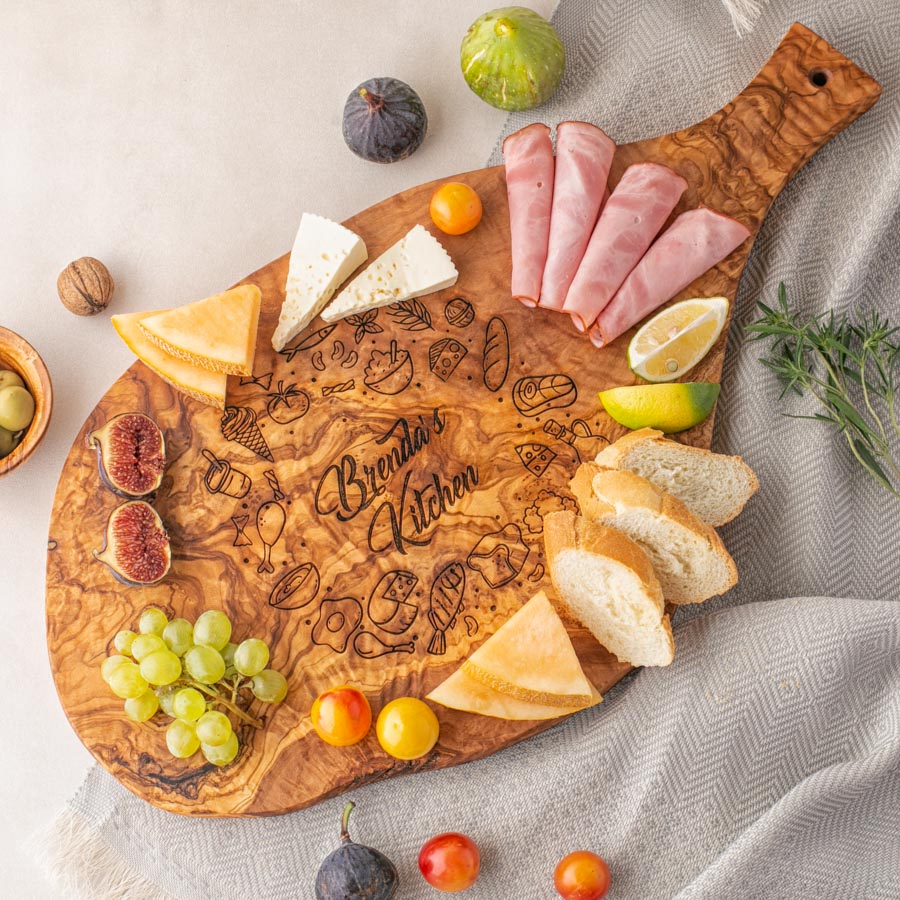 A Large serving board engraved with fruit and cheese on it.