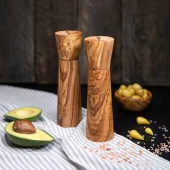 Two wooden salt and pepper mills on a wooden table.