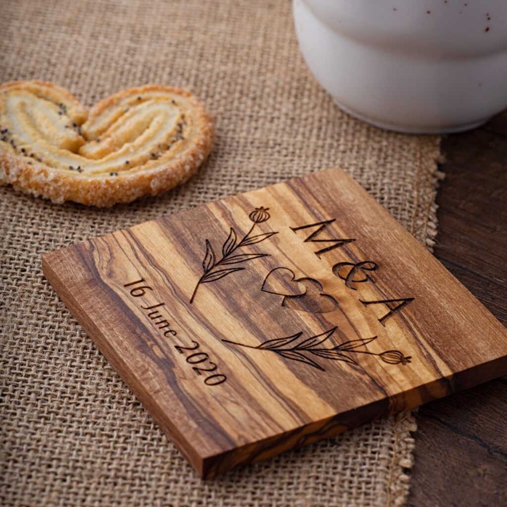 A Wooden Engraved Square Coaster with a cookie next to it.