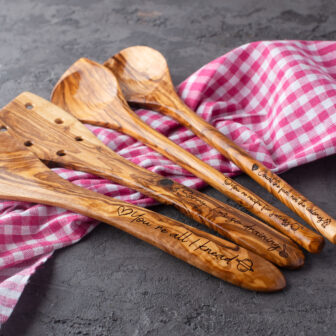 Four wooden spoons with engraved names on them.