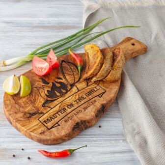 A Personalized Olive Wood Serving Board with tomatoes, onions and peppers on it.