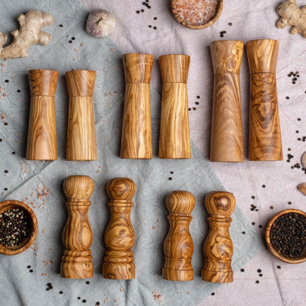 A group of wooden pepper grinders.