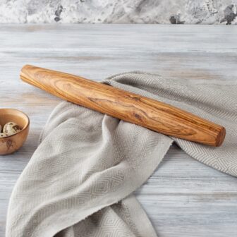 A wooden rolling pin on a wooden table.