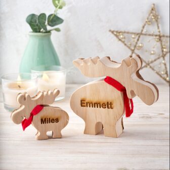 Two wooden moose ornaments with the name emmett.