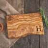 Olive wood cutting board with monogram engraved in the lower right corner.