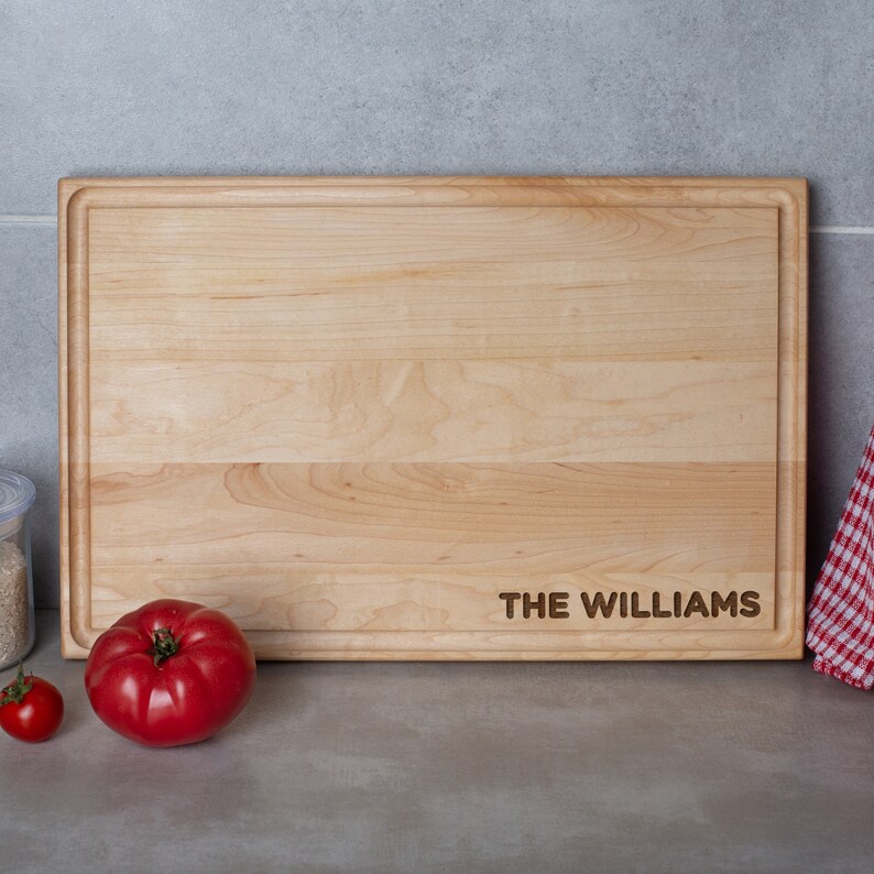 A wooden cutting board with the name the Williams.