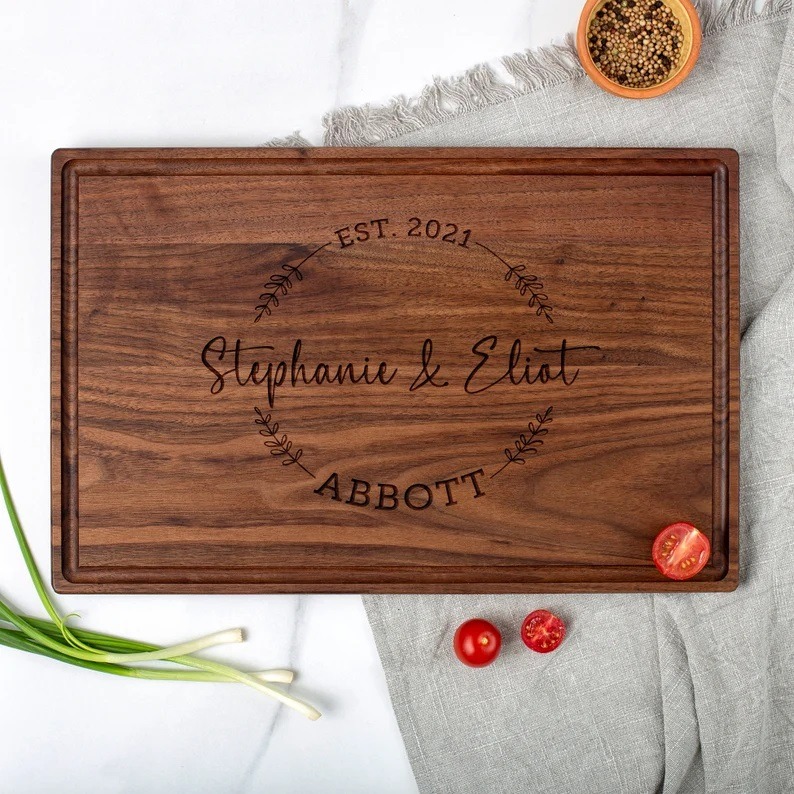personalized wooden wedding gift cutting board on top of a kitchen counter.
