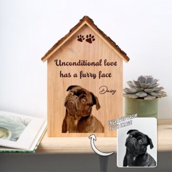 A wooden dog house with a picture of a pug on it.