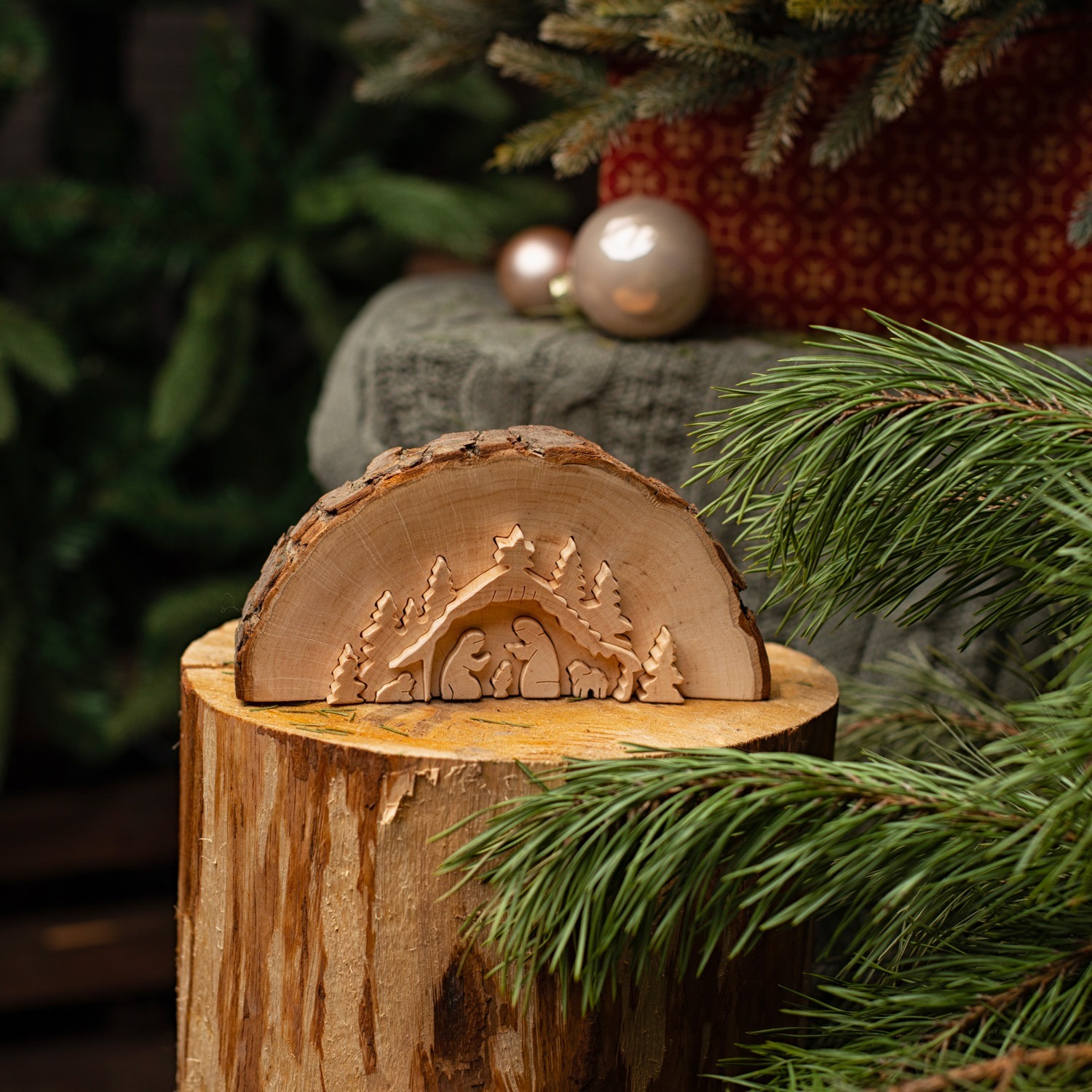 A wooden nativity scene on top of a tree stump.