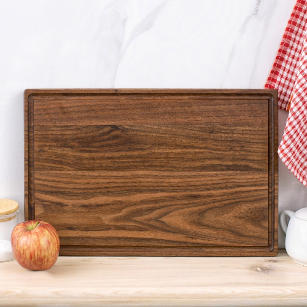 A wooden cutting board with an apple on it.
