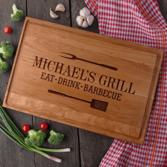 A Grill Master wooden cutting board with the words Michael's grill eat drink barbecue.