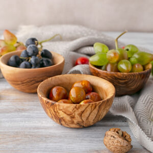 Three wooden bowls with grapes and walnuts.