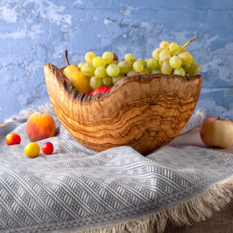A Olive Wood Salad Bowl with Live Edge with fruit in it.