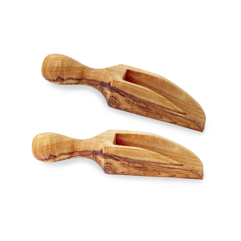 A pair of wooden salt spoons on a white background.