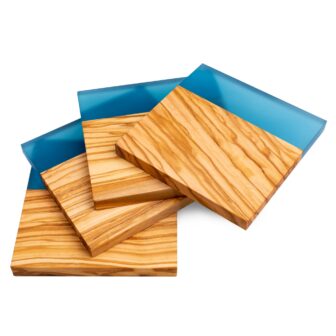 Three wooden coasters with natural grain patterns, stacked partially on top of each other on a blue background.