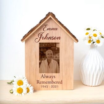 A wooden photo frame with a photo of a woman in a house.