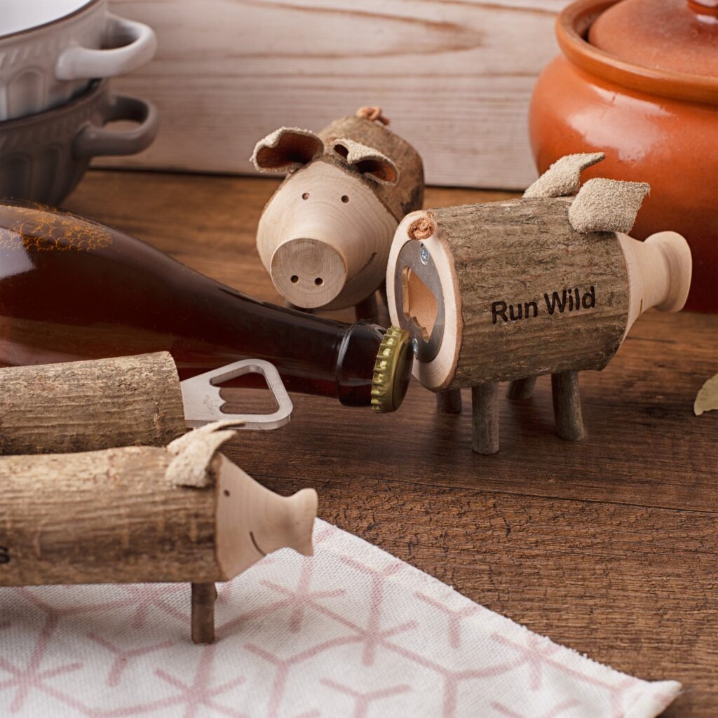 A wooden bottle opener with pigs on it.