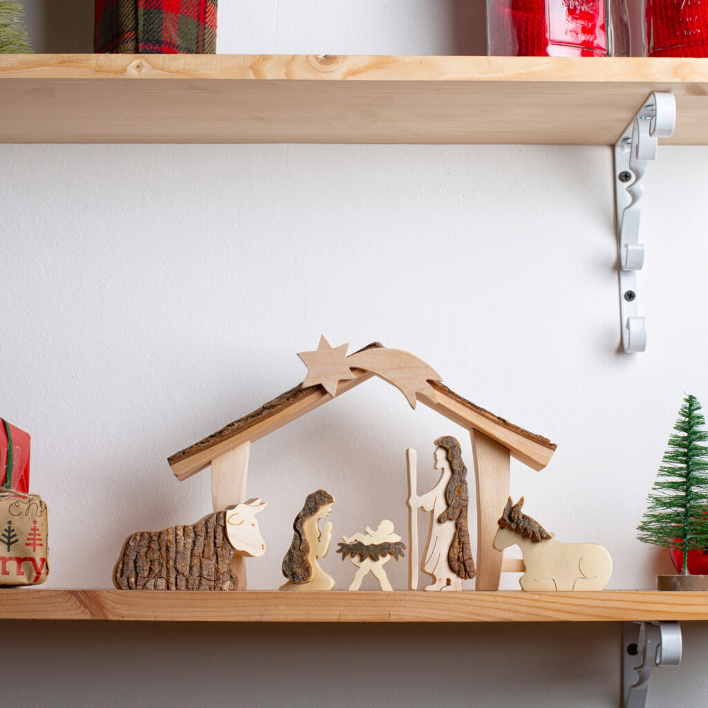 A shelf with a wood nativity scene on it.
