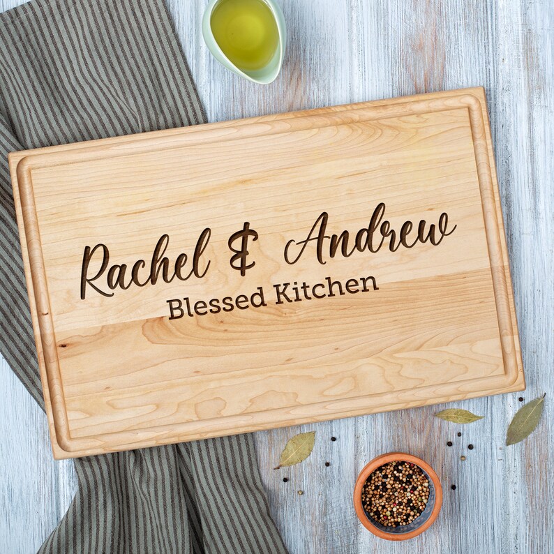 Customized maple cutting board with engraved couple's name across.
