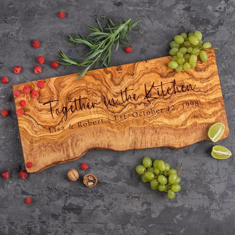 A Personalized Live Edge Cheese Board with fruit around it