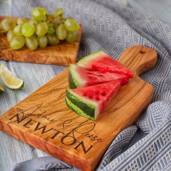 A Personalized Olive Wood Paddle Board with watermelon and grapes on it.