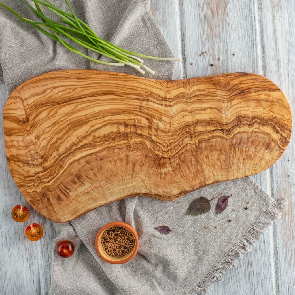Artisanal oval wooden cutting board with live edge and custom engraving