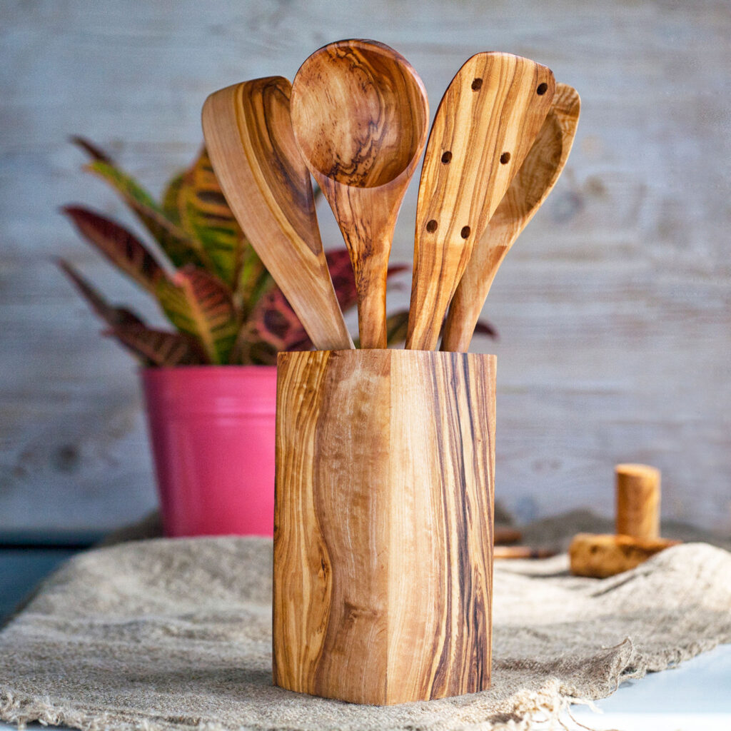 A set of wooden utensils in a wooden holder.