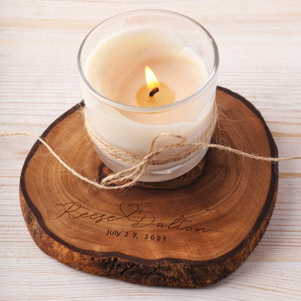 A candle sits on top of a Personalized Wooden Engraved Round Coasters Set