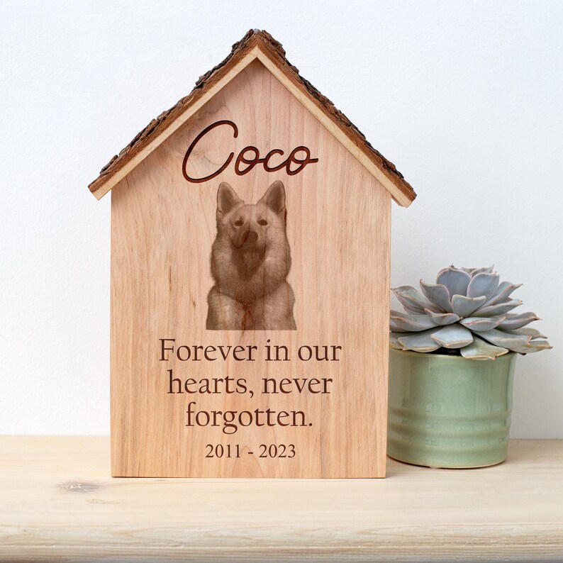 A wooden dog house with the words forever in our hearts never forgotten.