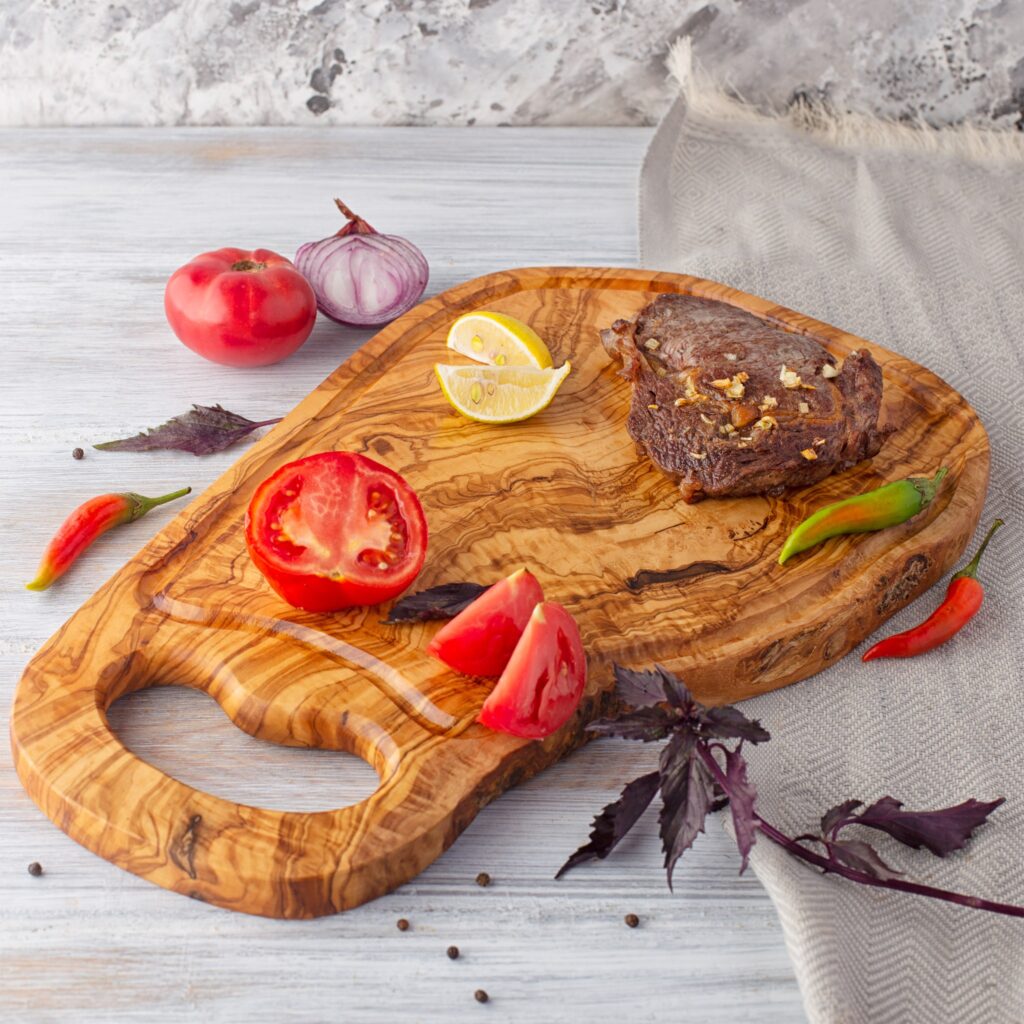 A BBQ Cutting Board with meat and vegetables on it.