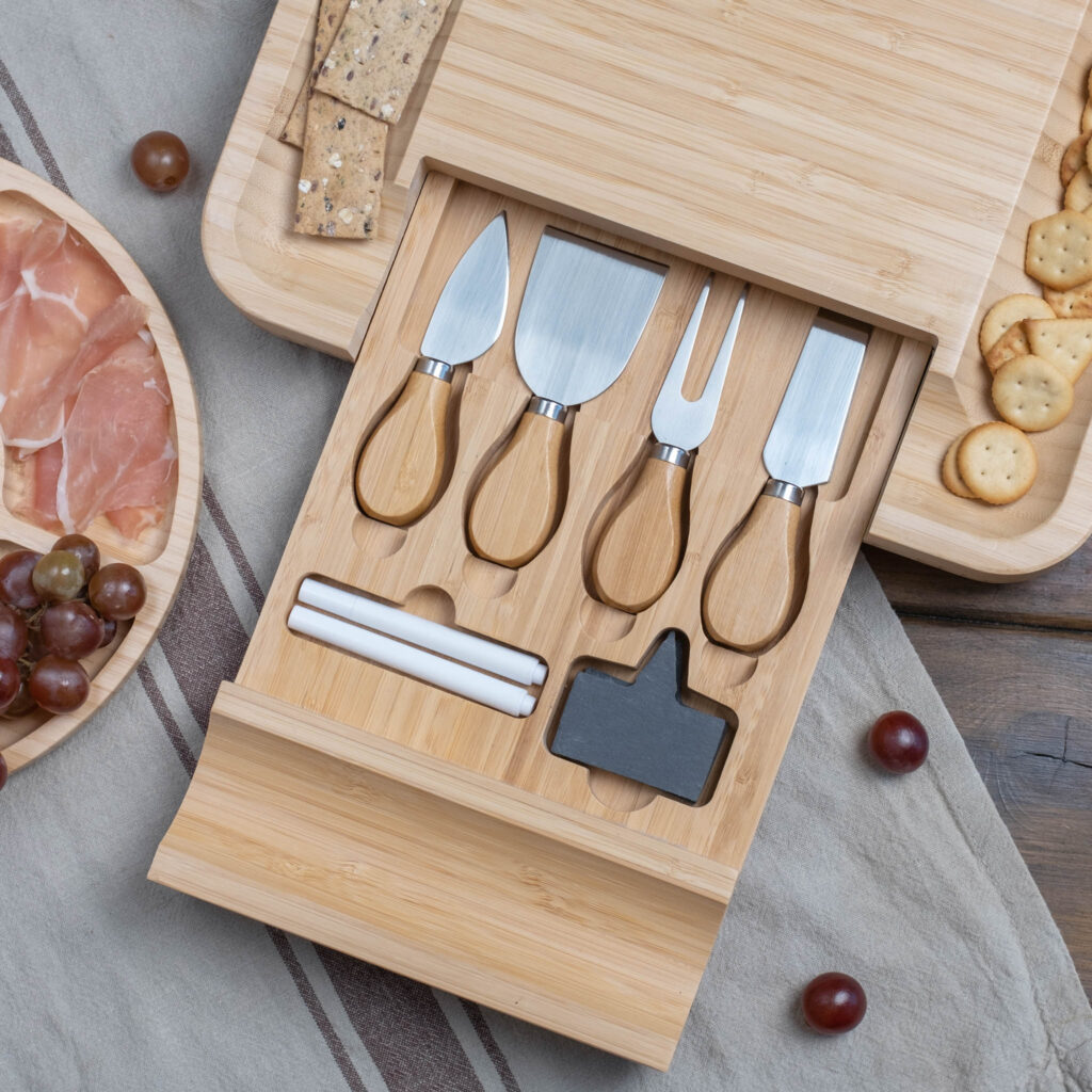 A cheese board with a set of knives and appetizers.