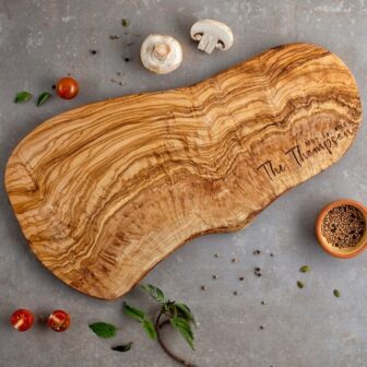 Personalized olive wood cheese board with engraved couple's last name in the right corner.