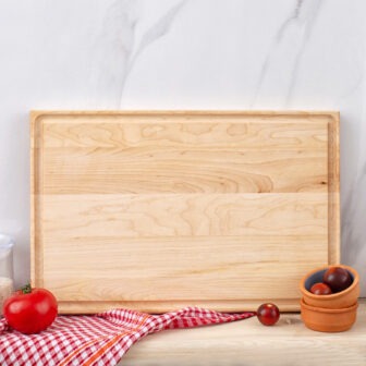 A wooden cutting board on a marble countertop.