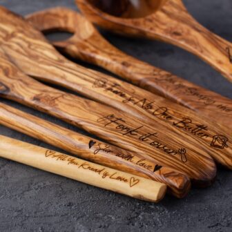 A set of wooden spoons with engraved names on them.