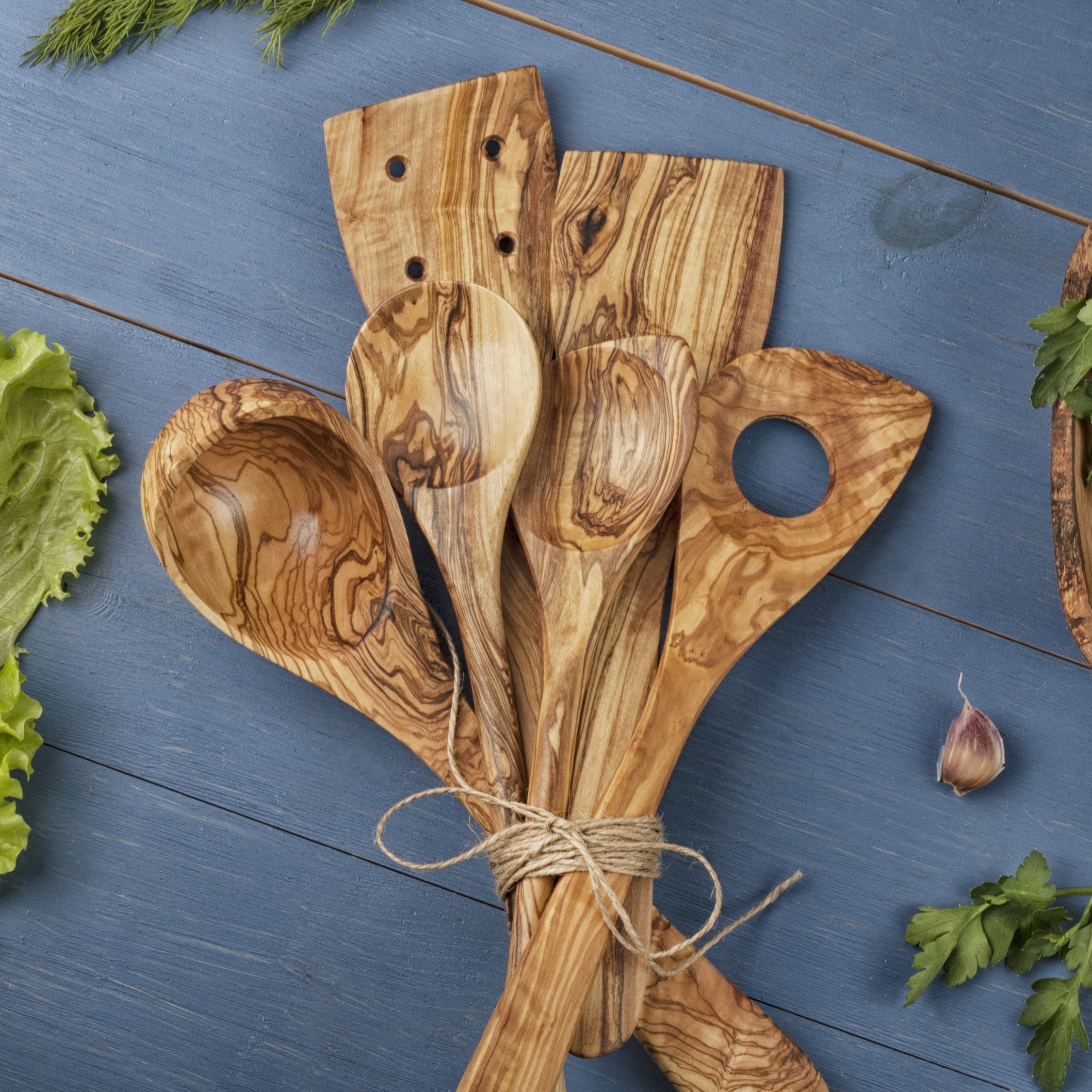 Wooden cooking utensils on a blue background.