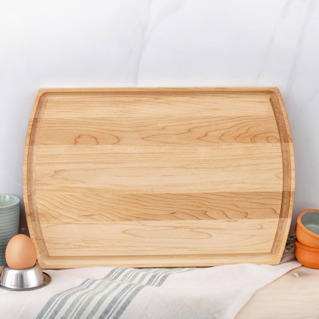 A wooden cutting board with eggs and utensils on it.