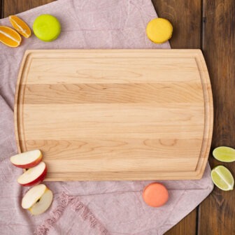 A wooden cutting board with oranges and lemons on it.