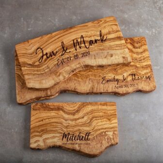 Three Personalized Live Edge Serving Boards with the names of the bride and groom written on them.