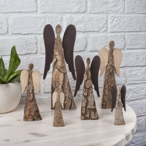 Five wooden angels on a table next to a potted plant.