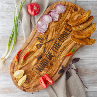 A personalized bbq cutting board with onions and tomatoes on it.