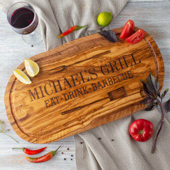 A wooden cutting board with the words michael grill and a glass of wine.