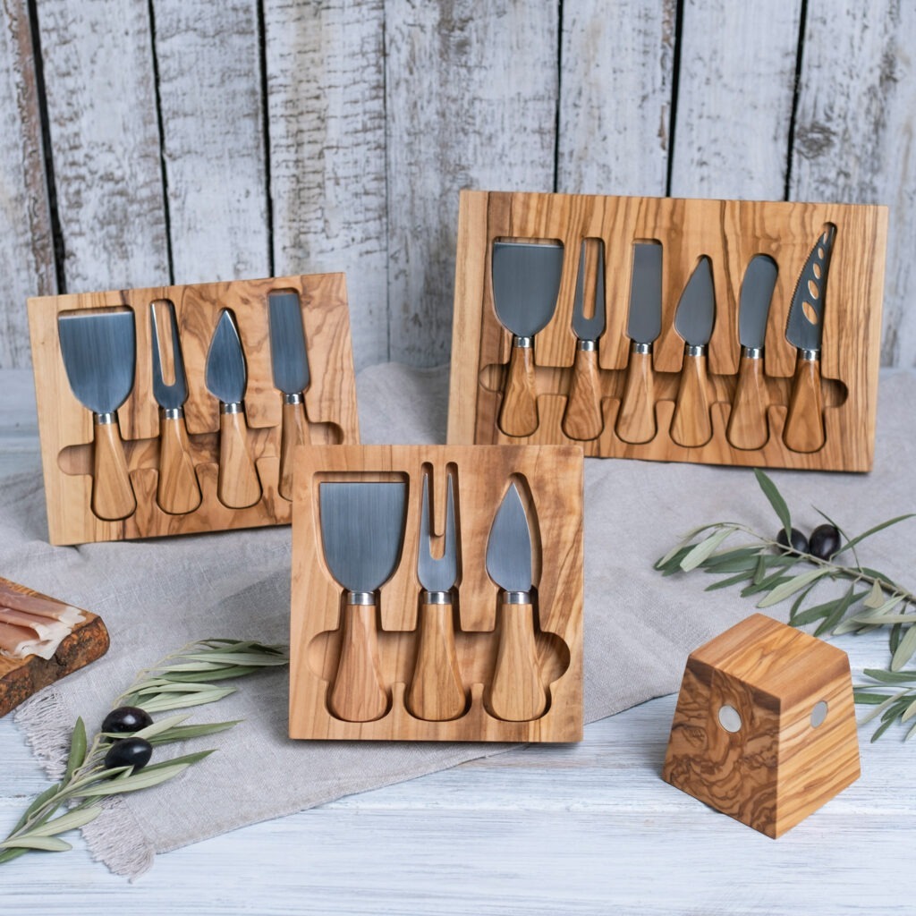 A wooden cheese knife set with olives and olives.